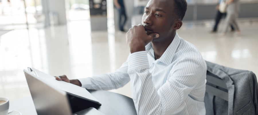 Salesman sitting at desk in car dealership.